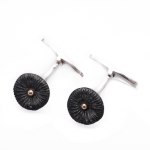 Fossil-oxiderat silver med 18k guldknopp i mitten. Pris 950 kr.