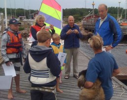 Kenned Falk avtackar seglingsledaren och brygghunden