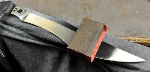 Blade being sanded after heat treat.